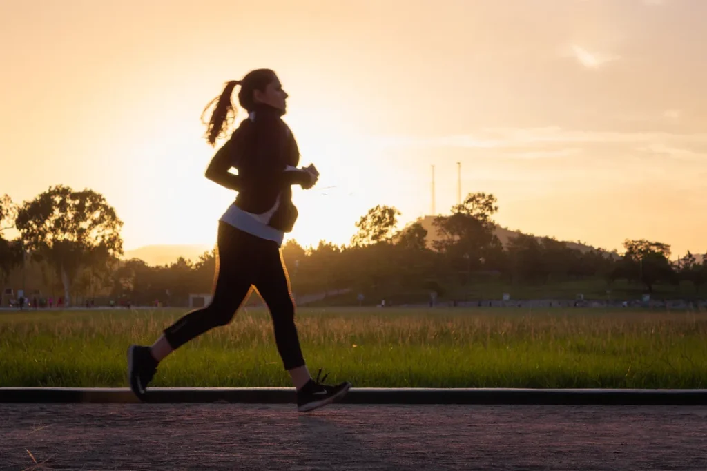 An image of a person walking briskly in a park, highlighting how exercise can improve vein health.